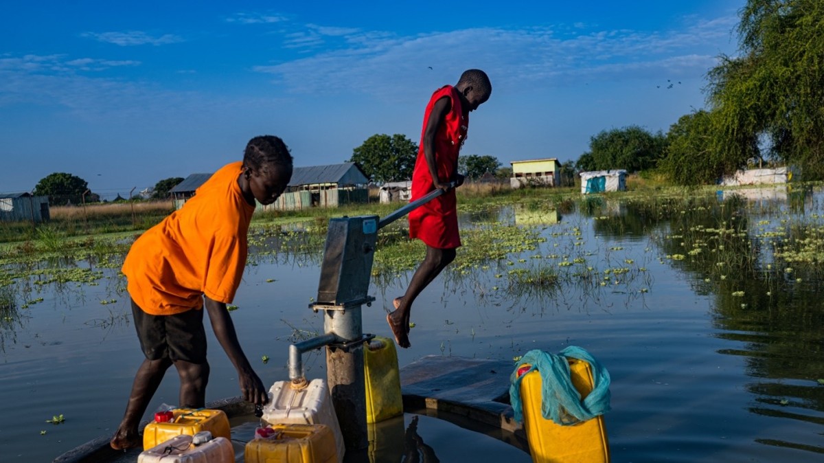Ajoh Majur, 12, uses her body weight to activate a handpump. South Sudan, Photo Credit: Lynsey Addario